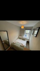 a small bedroom with a bed and a mirror at Whole house in Wiltshire in Chippenham