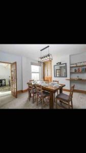 a dining room with a table and chairs and a chandelier at Whole house in Wiltshire in Chippenham