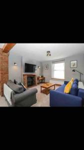 a living room with a blue couch and chairs at Whole house in Wiltshire in Chippenham