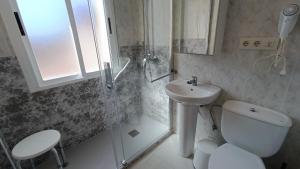 a bathroom with a shower and a toilet and a sink at Hotel Rural Martin in Baños de Montemayor