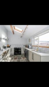 a kitchen with white cabinets and a large window at Whole house in Wiltshire in Chippenham