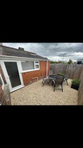 a patio with a table and chairs in front of a house at Whole house in Wiltshire in Chippenham