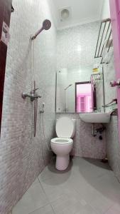 a bathroom with a shower and a toilet and a sink at Mami Hotel in Solok