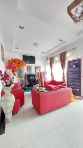 a living room with red furniture and a vase of flowers at Mami Hotel in Solok +10 photos