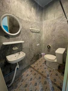 a bathroom with a toilet and a sink and a mirror at Just sleep in Ban Mo Nae