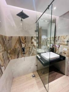 een badkamer met een wastafel en een glazen douche bij Luxury Studios Key 7 in Gurgaon