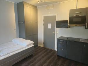 a small room with a bed and a tv at Oslo Airport Inn in Gardermoen