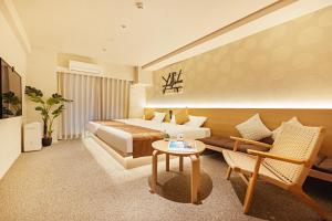 una camera d'albergo con letto e divano di Apartment Hotel 11 Namba ad Osaka