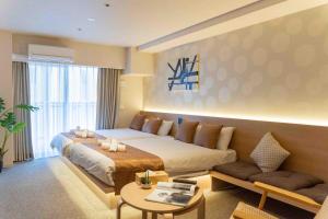 a bedroom with a large bed and a couch at Apartment Hotel 11 Namba in Osaka