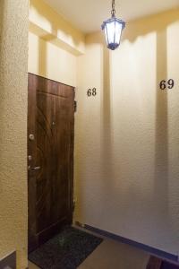 a hallway with a wooden door and a light at Raugyklos apartamentai in Vilnius