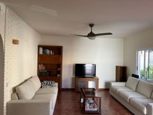 ein Wohnzimmer mit 2 Sofas und einem TV in der Unterkunft Casa mediterránea junto al mar. in Chilches