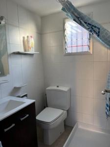 a bathroom with a toilet and a sink and a window at Casa mediterránea junto al mar. in Chilches +8 photos