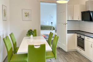uma cozinha e sala de jantar com mesa e cadeiras verdes em Ferienwohnung Malve em Lübbenau