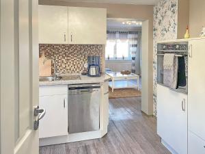 a kitchen with white cabinets and a sink at Ferienwohnung Sonnenring in Lübbenau