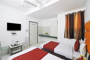 a hotel room with two beds and a television at Hotel Clink Stay Near Delhi IGI Airport in New Delhi