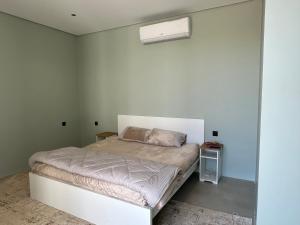 een slaapkamer met een bed met een witte muur bij مزرعة الخير 