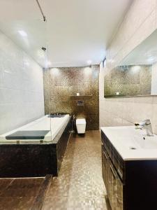 y baño con bañera, lavabo y aseo. en Hotel Gold Souk - Karol Bagh en Nueva Delhi