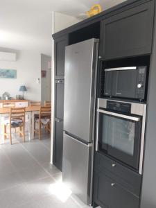 a kitchen with a refrigerator and a microwave at La Cigale - Pte des Gorges - Piscine privée chauffée in Vallon-Pont-dʼArc