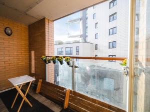 einen Balkon mit einer Bank und einem großen Fenster in der Unterkunft Pass The Keys Modern 2-Bed Apartment with Private Balcony, Near Dalston Junction Station - Ideal Urban Retreat! in London