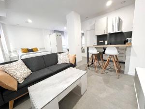 a living room with a couch and a kitchen at Studio Alborán in Málaga