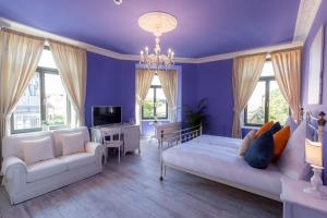 sala de estar con paredes de color púrpura, sofá y sillas en Grande Albergo Giancarlo, en Weimar