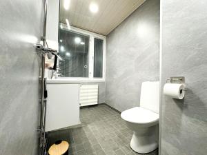 a small bathroom with a toilet and a window at Aurora City Studio By BookLapland in Rovaniemi