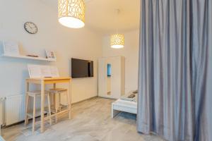 a room with a bed and a desk and a mirror at Gardencity Villa Apartman in Budapest