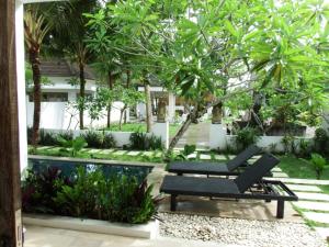 a garden with a bench and a swimming pool at Deepblue vila in Pulukan