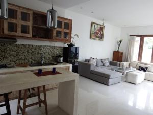 a kitchen and living room with a couch and a table at Deepblue vila in Pulukan