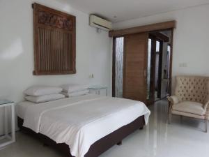 sypialnia z dużym łóżkiem i krzesłem w obiekcie Deepblue vila w mieście Pulukan