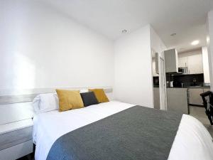 a bedroom with a large bed with yellow pillows at Studio Alborán in Málaga