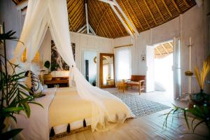 - une chambre avec un lit et une moustiquaire dans l'établissement Tropical Glamping Nusa Penida Diamond Beach - Cliff Side Edge, à Nusa Penida