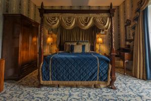 a bedroom with a bed with a blue comforter at Lough Rynn Castle in Mohill