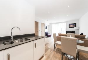 a kitchen and living room with a sink and a table at StayInn Greenwich in London
