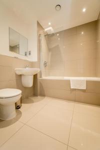 倫敦的住宿－StayInn Greenwich，浴室配有卫生间、盥洗盆和浴缸。