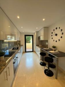 a large kitchen with a large clock on the wall at Appartement (4p) in Luxury Capanes Del Golf in Benahavís
