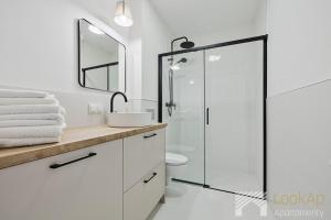 a white bathroom with a shower and a sink at Diasfera II by LookAp in Łódź