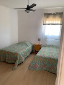 1 dormitorio con 2 camas y ventilador de techo en Las Casas Rurales de Los Olivos, en Tabernas