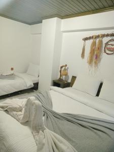 una camera con due letti con lenzuola bianche di Scala Otel a Çeşme