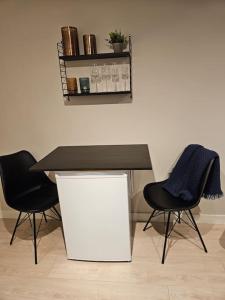 a table with two black chairs and a table with a blue towel at Studio apartment in Tromsø