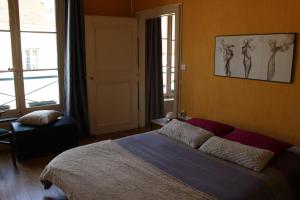 a bedroom with a bed with two drawings on the wall at La Lodge Victoria -Vieille Ville & Pépinière -50m2 in Nancy