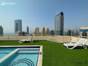 a swimming pool on the roof of a building at Opulent 1BR at Manchester Tower Dubai Marina by Deluxe Holiday Homes in Dubai