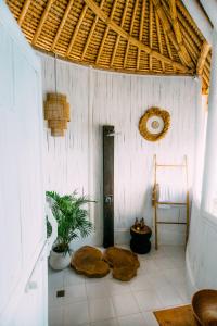 Tropical Glamping Nusa Penida Diamond Beach - Cliff Side Edge في نوسا بينيدا: غرفة بجدران بيضاء وسقف خشبي