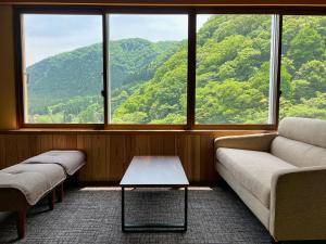 a living room with a couch and a table in front of a window at Yuze Hotel in Kazuno