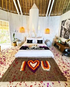 a bedroom with a bed with a heart made out of flowers at Tropical Glamping Nusa Penida Diamond Beach - Cliff Side Edge in Nusa Penida