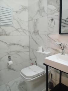 Baño blanco con aseo y lavamanos en Scala Otel, en Cesme