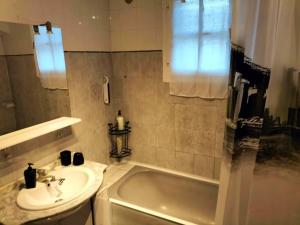 uma casa de banho com um lavatório e uma banheira em Appartement dans villa Niçoise em Nice