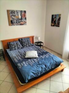 a bed with a blue comforter and pillows at Appartement dans villa Niçoise in Nice