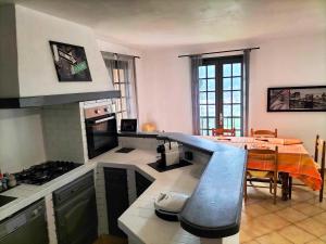 uma cozinha com um balcão e uma mesa em Appartement dans villa Niçoise em Nice