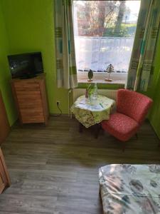 Zimmer mit einem Tisch, einem Stuhl und einem Fenster in der Unterkunft Pension Sander in Bispingen